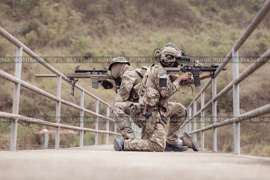 Soldiers in camouflage military uniforms carrying weapons, Reconnaissance missions in the tropical forest area, Assault infantry battle training. Стоковое фото, агентство Ingram Publishing / Фотобанк Лори