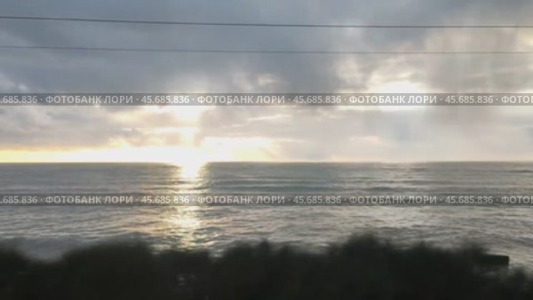 Солнечные лучи и морские волны по дороге в скоростном электропоезде Ласточка мартшрут Сочи - Туапсе в декабре. Видео. Стоковое видео, видеограф Денис Костров / Фотобанк Лори