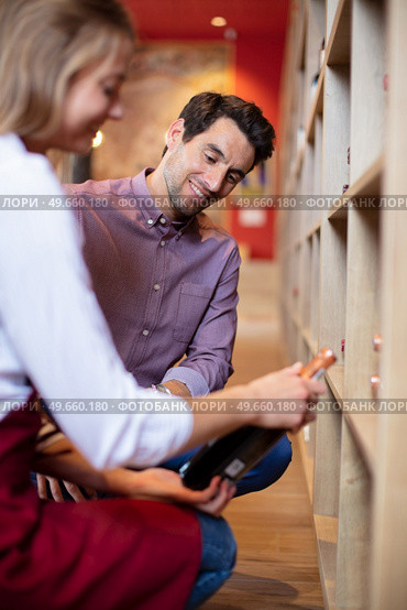 sommelier in wine store giving recommendation for bottle of wine. Стоковое фото, агентство Ingram Publishing / Фотобанк Лори