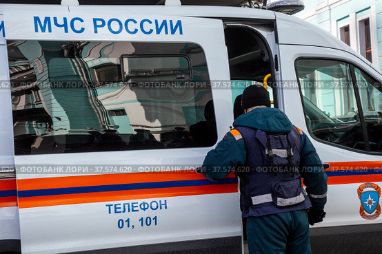 Сотрудник МЧС России садится в автомобиль специальной службы у здания Белорусского вокзала в городе Москве, Россия (2022 год). Редакционное фото, фотограф Николай Винокуров / Фотобанк Лори