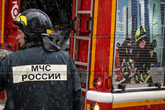 Сотрудник пожарного расчета принимает участие в тушении пожара в центре города Москвы, Россия. Редакционное фото, фотограф Николай Винокуров / Фотобанк Лори