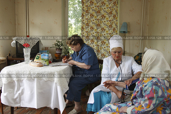 Социальный работник у пенсионера дома (2009 год). Редакционное фото, фотограф Дмитрий Неумоин / Фотобанк Лори