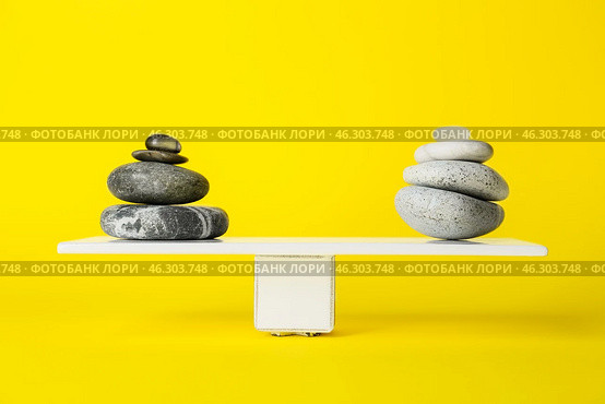 Spa stones on teeterboard against yellow background. Concept of balance. Стоковое фото, фотограф Pixel_shot / Фотобанк Лори
