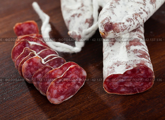 Spanish sausage fuet on a wooden table, closeup. Стоковое фото, фотограф Яков Филимонов / Фотобанк Лори