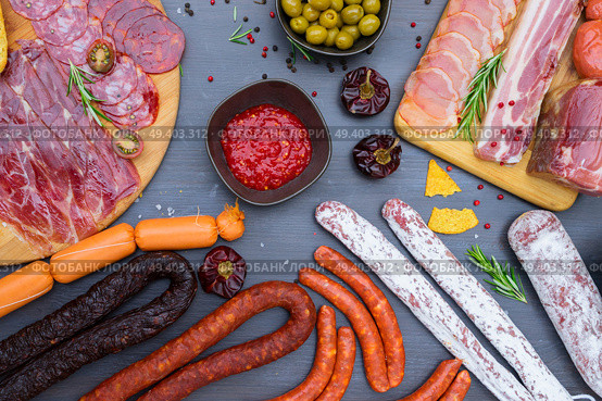 spanish tapas with pancetta, salami, chorizo, lomo, jamon with red hol salsa sause and olives, picnic table, top view. Picnic table with spanish sausage tapas. Стоковое фото, агентство Ingram Publishing / Фотобанк Лори