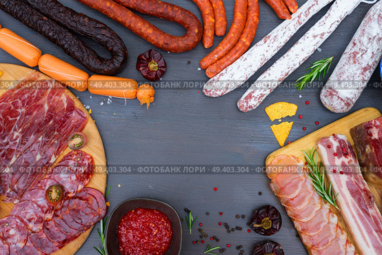 spanish tapas with salami, chorizo, lomo, jamon with red hol salsa sause and olives, picnic table, top view frame with copy space. Picnic table with spanish sausage tapas. Стоковое фото, агентство Ingram Publishing / Фотобанк Лори