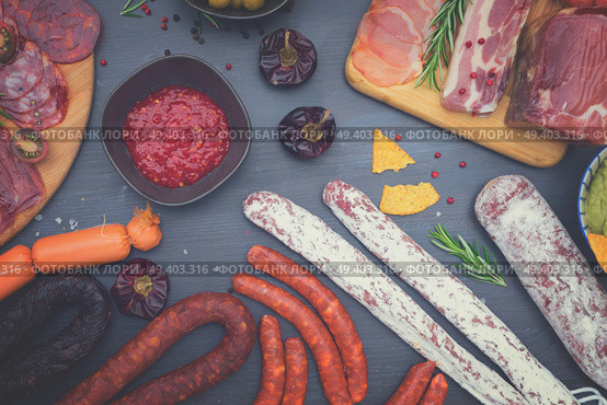 spanish tapas with salami, chorizo, lomo, jamon with red hol salsa sause and olives, picnic table, top view, retro toned. Picnic table with spanish sausage tapas. Стоковое фото, агентство Ingram Publishing / Фотобанк Лори