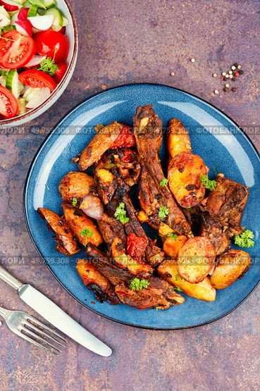 Spare ribs or grilled ribs with stewed vegetables. Barbecue ribs.. Grilled meat ribs with fried potato. Стоковое фото, агентство Ingram Publishing / Фотобанк Лори