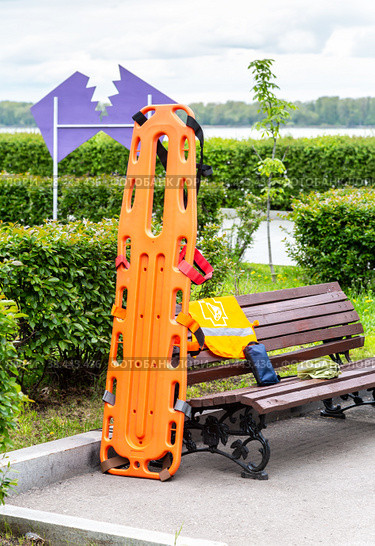 Special orange plastic medical stretcher in the city park (2022 год). Редакционное фото, фотограф FotograFF / Фотобанк Лори