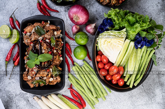 Spicy pork chops on a black plate consisting of lemons Chili and side dishes. Selective focus. Стоковое фото, агентство Ingram Publishing / Фотобанк Лори