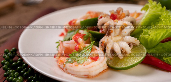 Spicy Squid and Shrimp Salad in White Dish with Lemon Cilantro and lettuce. Стоковое фото, агентство Ingram Publishing / Фотобанк Лори