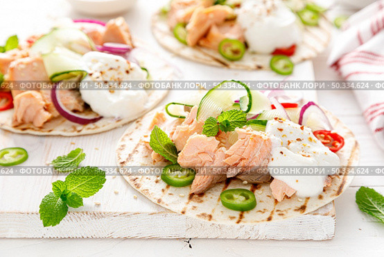 Spicy tacos with grilled salmon, vegetables, ricotta cheese, chili and fresh mint. Стоковое фото, агентство Ingram Publishing / Фотобанк Лори