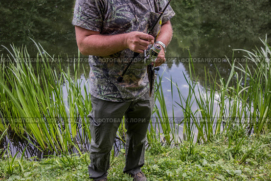 Спиннинг и пойманная рыба в мужских руках/ Hunting and fishing, men's hobby. Sport fisherman holding trophy fish. Стоковое фото, фотограф Iva Noel / Фотобанк Лори