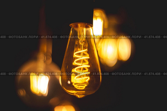 Spiral Retro light bulbs hanging on a dark background. Electricity, Vintage. Стоковое фото, фотограф Ольга Ильина / Фотобанк Лори