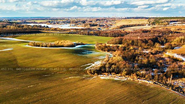 Spring rural aerial landscape. Spring melting snow on march agricultural fields. Minsk city on background. winter crops and plowed field. Belarus . Стоковое фото, агентство Ingram Publishing / Фотобанк Лори