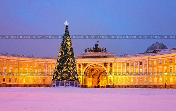 St. Petersburg in Christmas holidays. Decorated Christmas tree on a snowy Palace Square against the background of General Staff Building. Translation inscription at base of tree: Merry Christmas and Happy New Year (2019 год). Стоковое фото, фотограф Виктория Катьянова / Фотобанк Лори