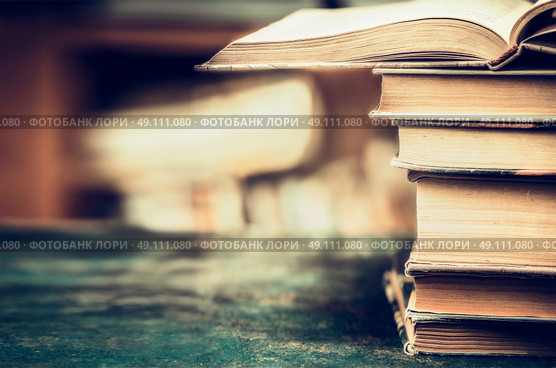 Stack of books on aged table, close up, place for text, retro styled. Стоковое фото, агентство Ingram Publishing / Фотобанк Лори
