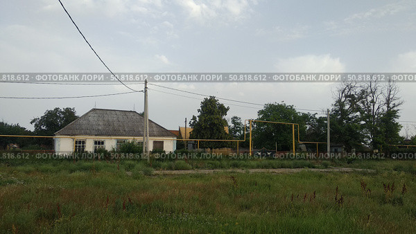Старый дом на сельской улице с газопроводом. Заброшенный пионерский лагерь (2021 год). Редакционное фото, фотограф Мария Сергеева / Фотобанк Лори