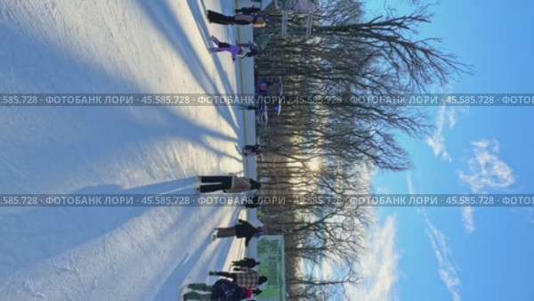Ставрополь, парк Победы - Люди катаются на коньках на открытом катке в городском парке. Зимний городской пейзаж с толпой людей на открытом катке. Новогодние и Рождественские каникулы. Вертикальное видео. Редакционное видео, видеограф Ирина Михайличенко / Фотобанк Лори