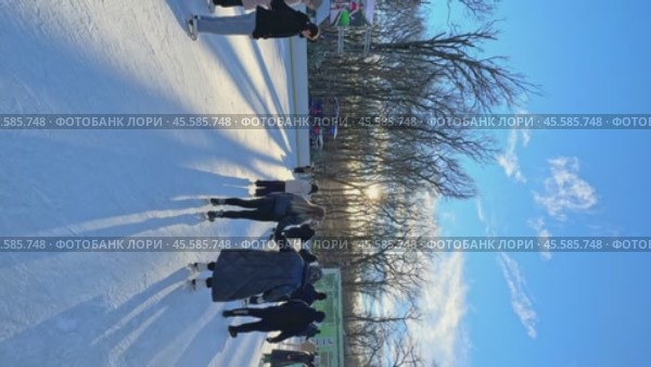 Ставрополь, парк Победы - Люди катаются на коньках на открытом катке в городском парке. Зимний городской пейзаж с толпой людей на открытом катке. Новогодние и Рождественские каникулы. Вертикальное видео. Редакционное видео, видеограф Ирина Михайличенко / Фотобанк Лори