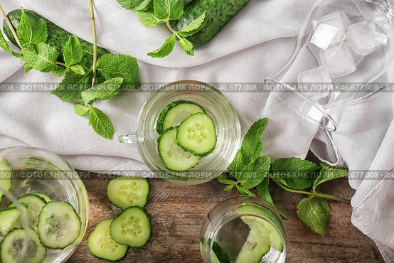 Стеклянная чашка вкусной свежей огуречной воды на деревянном столе. Стоковое фото, фотограф Pixel_shot / Фотобанк Лори