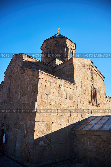 Stepantsminda, Georgia - January 03, 2023: Gergeti Church of the 14th century at the foot of Mount Kazbek. Редакционное фото, фотограф Наталия Кирсанова / Фотобанк Лори