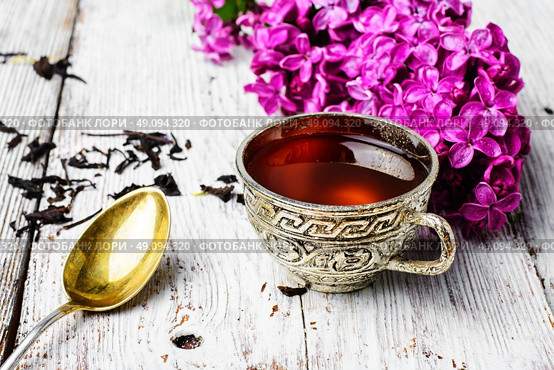 Still life with tea and branch of lilac. Stylish and fashionable cup of tea and branch of blossoming lilac. Стоковое фото, агентство Ingram Publishing / Фотобанк Лори