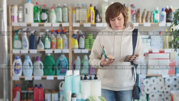 Store visitor woman purchases in household chemicals department, choose eye shadow pallet. Стоковое видео, видеограф Яков Филимонов / Фотобанк Лори