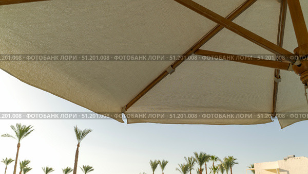 Straw sun umbrella by the sun lounger. Стоковое фото, фотограф Igor Skripachev / Фотобанк Лори