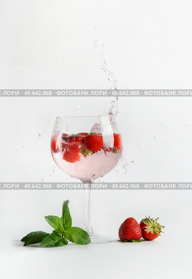 Strawberry mocktail with mint in  glass with splashing at white background. Refreshing summer non-alcoholic drink with berries. Front view. Стоковое фото, агентство Ingram Publishing / Фотобанк Лори