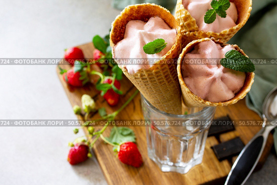 Strawberry of ice cream scoops in cones on a light stone or slate table. Free space for your text. Стоковое фото, агентство Ingram Publishing / Фотобанк Лори