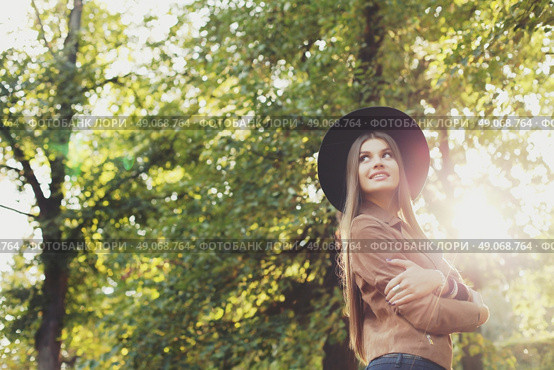 Street fashion concept - closeup portrait of a pretty girl. Wearing hat and suede jacket holding bag with fringe. Beautiful autumn woman. . Стоковое фото, агентство Ingram Publishing / Фотобанк Лори