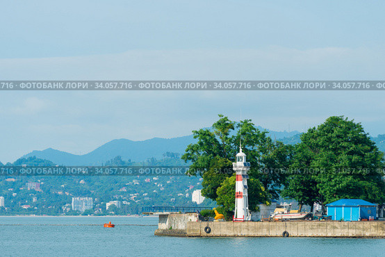 Striped lighthouse on the city shore, photograph on a clear day. Стоковое фото, фотограф Константин Лабунский / Фотобанк Лори