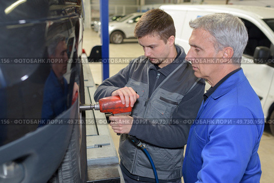 student with instructor repairing a car during apprenticeship. Стоковое фото, агентство Ingram Publishing / Фотобанк Лори