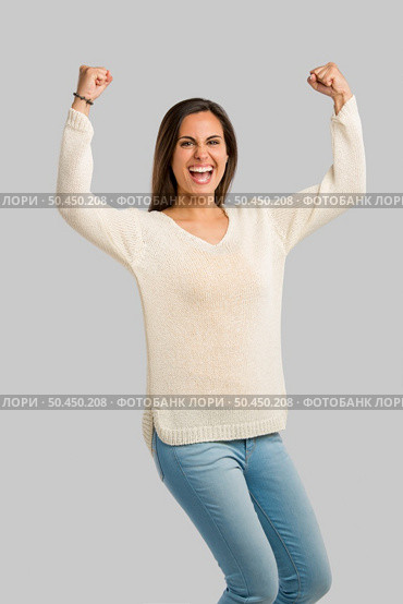 Studio shot of a happy young woman with arms raised. Стоковое фото, агентство Ingram Publishing / Фотобанк Лори