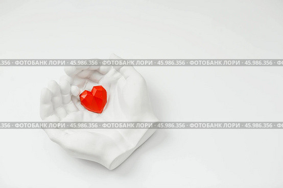 Stylish banner. In his hands, a red heart on a white background is made of plaster. World Health, Love and Insurance Day. World Heart, Health and Organ Donor Day. Стоковое фото, фотограф Photojuli / Фотобанк Лори
