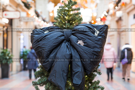 Stylish black bow on the Christmas tree. Beautiful Christmas background. Concept of preparing decorations and furnishings for the New Year. New Year's card 2026. Стоковое фото, фотограф Photojuli / Фотобанк Лори