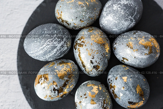 Stylish grey Easter eggs made of marble and concrete with a golden potala on a grey background. Coloring eggs with natural dye karkade tea. . The concept of a happy Easter. Стоковое фото, фотограф Photojuli / Фотобанк Лори