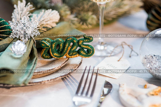 Stylish plates, napkin, glass, champagne, Christmas tree branches and Christmas decorations on a gray background. Table setting. The concept of Merry Christmas and New Year 2025. Стоковое фото, фотограф Photojuli / Фотобанк Лори