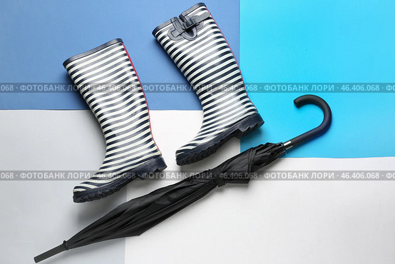 Stylish umbrella and gumboots on color background. Стоковое фото, фотограф Pixel_shot / Фотобанк Лори
