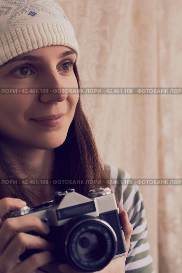 Stylish woman in hat holding vintage photo camera. Portrait of brunette girl with retro photo camera. Стоковое фото, фотограф Константин Григорьев / Фотобанк Лори