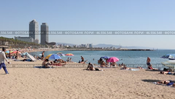 Summer view of lively popular Barceloneta beach with two modern skyscrapers rising in background on sunny day (2022 год). Редакционное видео, видеограф Яков Филимонов / Фотобанк Лори