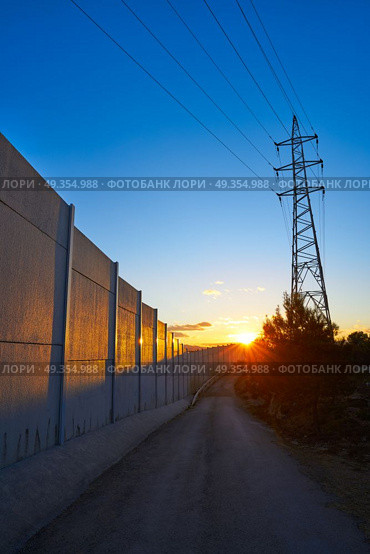 Sunset in a track with electric tower and concrete. Sunset in a track with electric tower and concrete wall. Стоковое фото, агентство Ingram Publishing / Фотобанк Лори