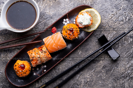 sushi roll set served  at black tray at grey table. flat lay . Стоковое фото, агентство Ingram Publishing / Фотобанк Лори