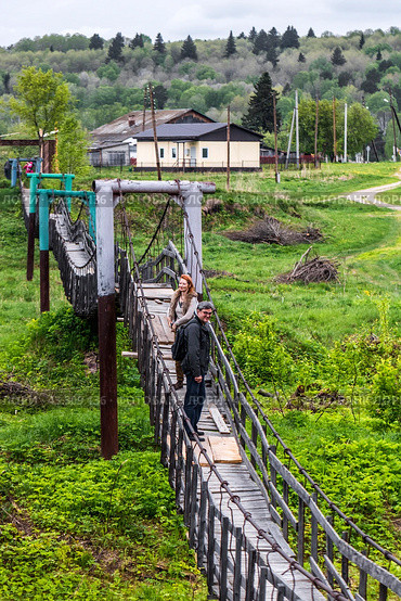 Suspension bridge over the Suenga River. Western Siberia (2024 год). Редакционное фото, фотограф Евгений Мухортов / Фотобанк Лори