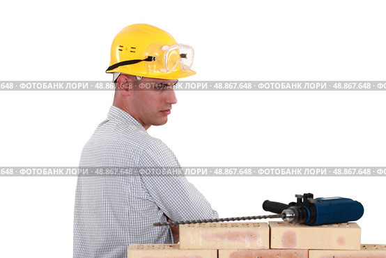 Suspicious man looking at an electric screwdriver. Стоковое фото, агентство Ingram Publishing / Фотобанк Лори