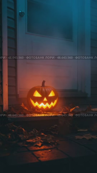 Светящаяся тыква на Хэллоуин с вырезанным лицом на крыльце ночью. Стоковое AI-видео, аниматор Ольга Невская / Фотобанк Лори