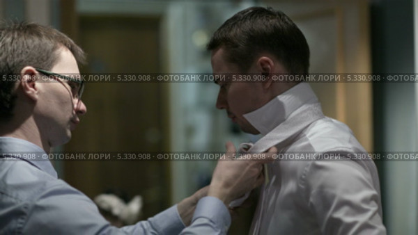 Свидетель помогает жениху одеваться. Стоковое видео, видеограф Данил Руденко / Фотобанк Лори