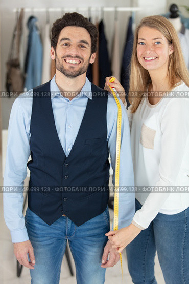 tailor standing near male client with measuring tape. Стоковое фото, агентство Ingram Publishing / Фотобанк Лори