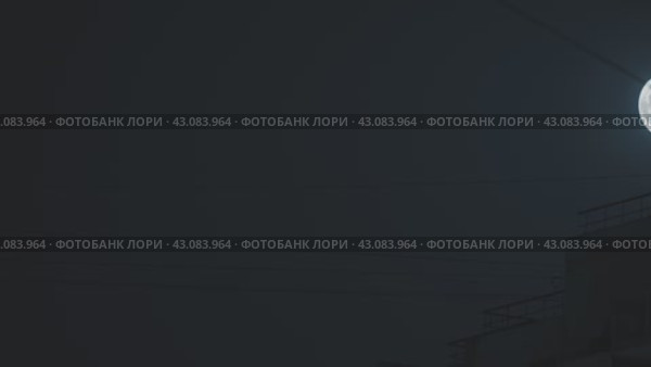 Таймлапс полной луны на черном небе. Электрические провода и силуэт здания на заднем плане. Камера медленно уходит вдаль. Захватывающая и сюрреалистичная ночная сцена. Стоковое видео, видеограф Воловодов Владимир / Фотобанк Лори